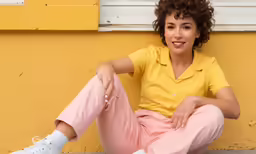 a woman in yellow shirt sitting on the ground