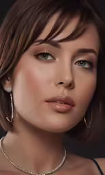 the woman in earrings poses with her eyes closed