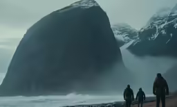 three people walking by the water and mountains