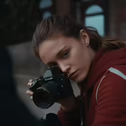 a woman holding up a camera in front of her face