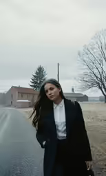 a beautiful young woman walking down the middle of a street
