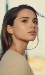 a woman is standing outside with hair blowing in the wind