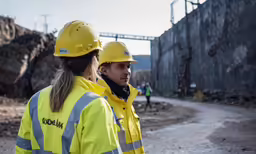 two women in hard hats talk with each other