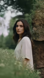 a young woman standing in a flower filled field