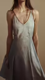 a woman in a silver dress with her hair in sideburns