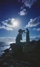 two people sitting on rocks look at the water with a camera