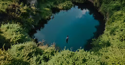 a man in a small boat in the middle of a river