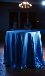 a light shining on a table draped with a blue cloth