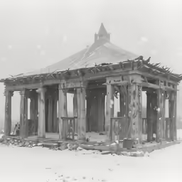 a large building standing in the snow with a tower