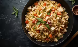 a large bowl of pasta, with vegetables on the side