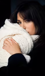 a girl is wrapped in a blanket looking off to the side