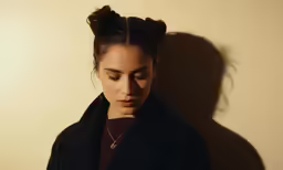 the young asian woman is looking down at her cell phone