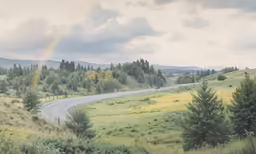 a rainbow in the sky with clouds and a rainbow in the distance