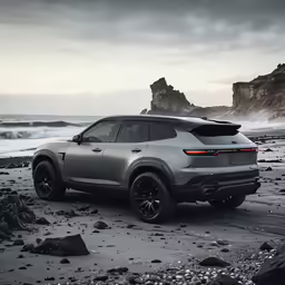 a grey car on the beach next to rocks
