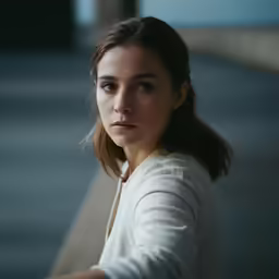 a young woman sitting on top of a bench