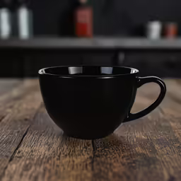a black coffee cup sitting on top of a wooden table