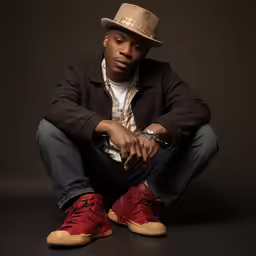 the man in a hat is wearing a brown jacket and sneakers