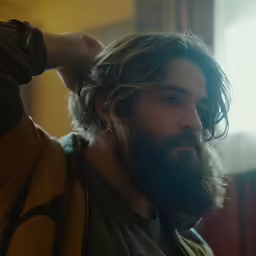 a man with a beard and bearding combs his hair