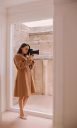 the woman is holding up her camera and taking pictures