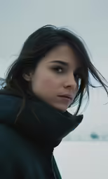 a woman is in the snow with her head turned