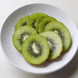 a white plate topped with sliced green kiwis