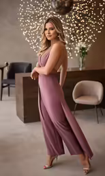 a beautiful blonde woman wearing a purple jumpsuit