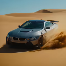 a bmw sports car driving in the sand dunes