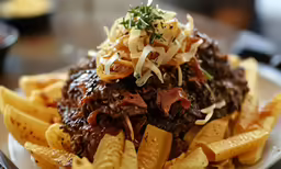 a white plate topped with pasta covered in meat and sauce