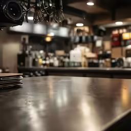 an empty counter inside a restaurant, with silver cups in the middle