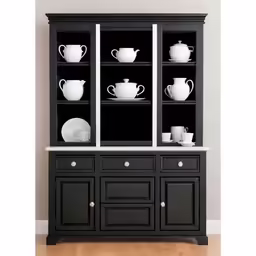 a black display cabinet holds china plates, cups and pitchers