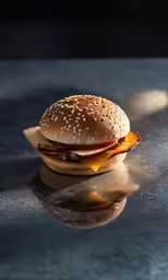 a bacon cheeseburger sitting on top of a table