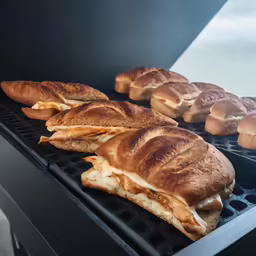 bread sandwiches are cooking on the grill outside