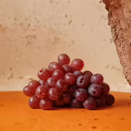 a cluster of grapes on an orange surface