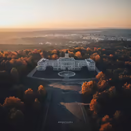 a large white building with a dome and a circular pool surrounded by trees