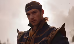 a man in costume wearing a blindfold and standing outside