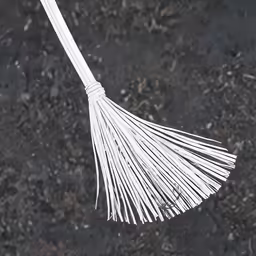 a broom hanging upside down on top of some grass
