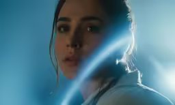 the beautiful young woman is holding her hand up