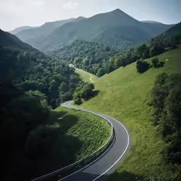 a scenic road in the middle of a valley with green mountains in the background