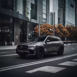 a grey mercedes is driving down a city street