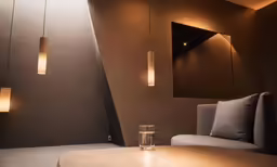 a table with a glass and some lamps next to it