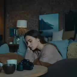 a girl in the living room is taking a photo of herself