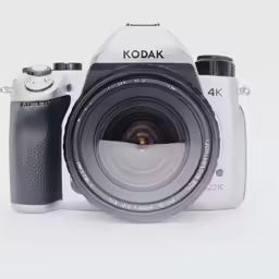 a camera, a lens and a flash on a white surface