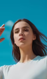 a woman wearing white shirt and holding her hair up