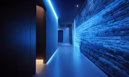 an alley with walls made of rocks illuminated in blue lights