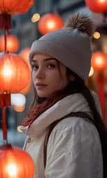 woman in winter clothing and hat at street with orange lanterns