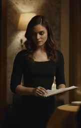 a girl holding a book standing in a room
