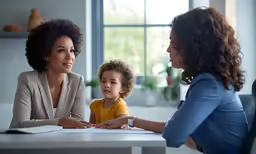 a mother and son with a child sitting at a table