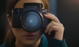 a woman holding a camera up to the lens