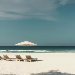 beach with umbrella and lawn chairs on sunny day