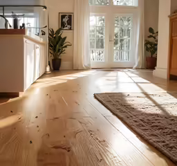 a spacious room has some light and a large wooden table